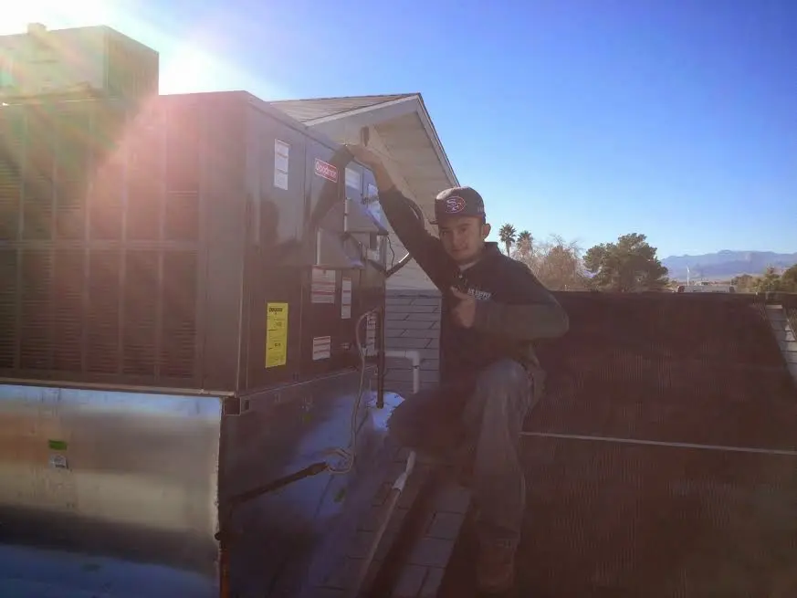 HVAC technician performing AC Tune-Up on a rooftop unit in Vandalia